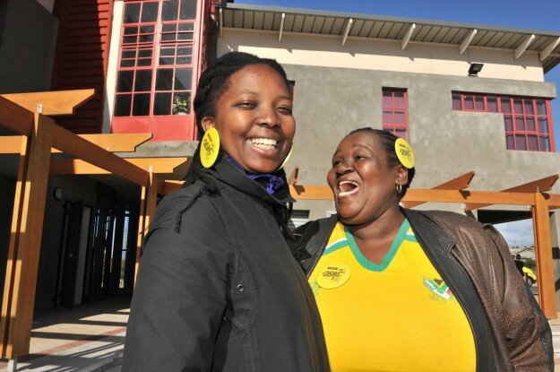 Two supporters of Cape Town as World Design Capital 2014 in front of Khayelitsha's Violence Prevention through Urban Upgrading program.